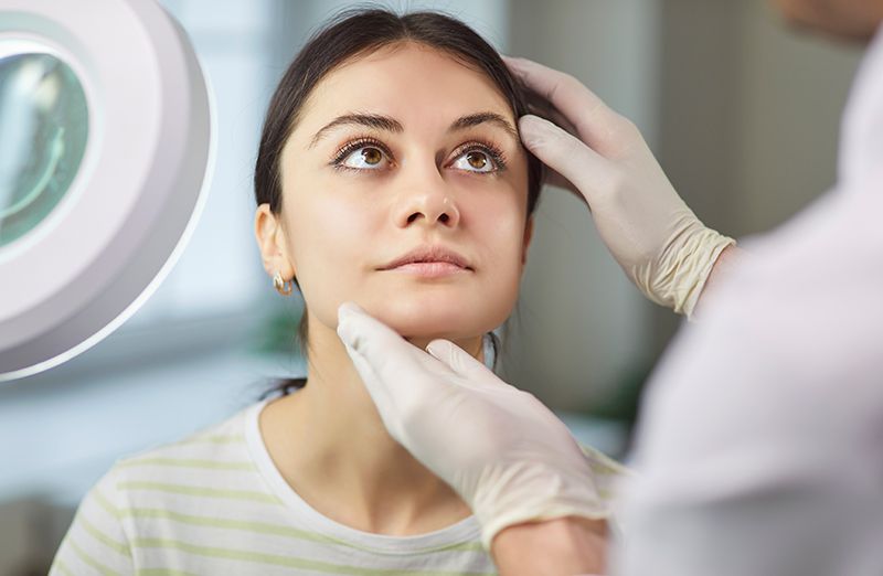 Woman consulting a plastic surgeon on facial rejuvenation options.